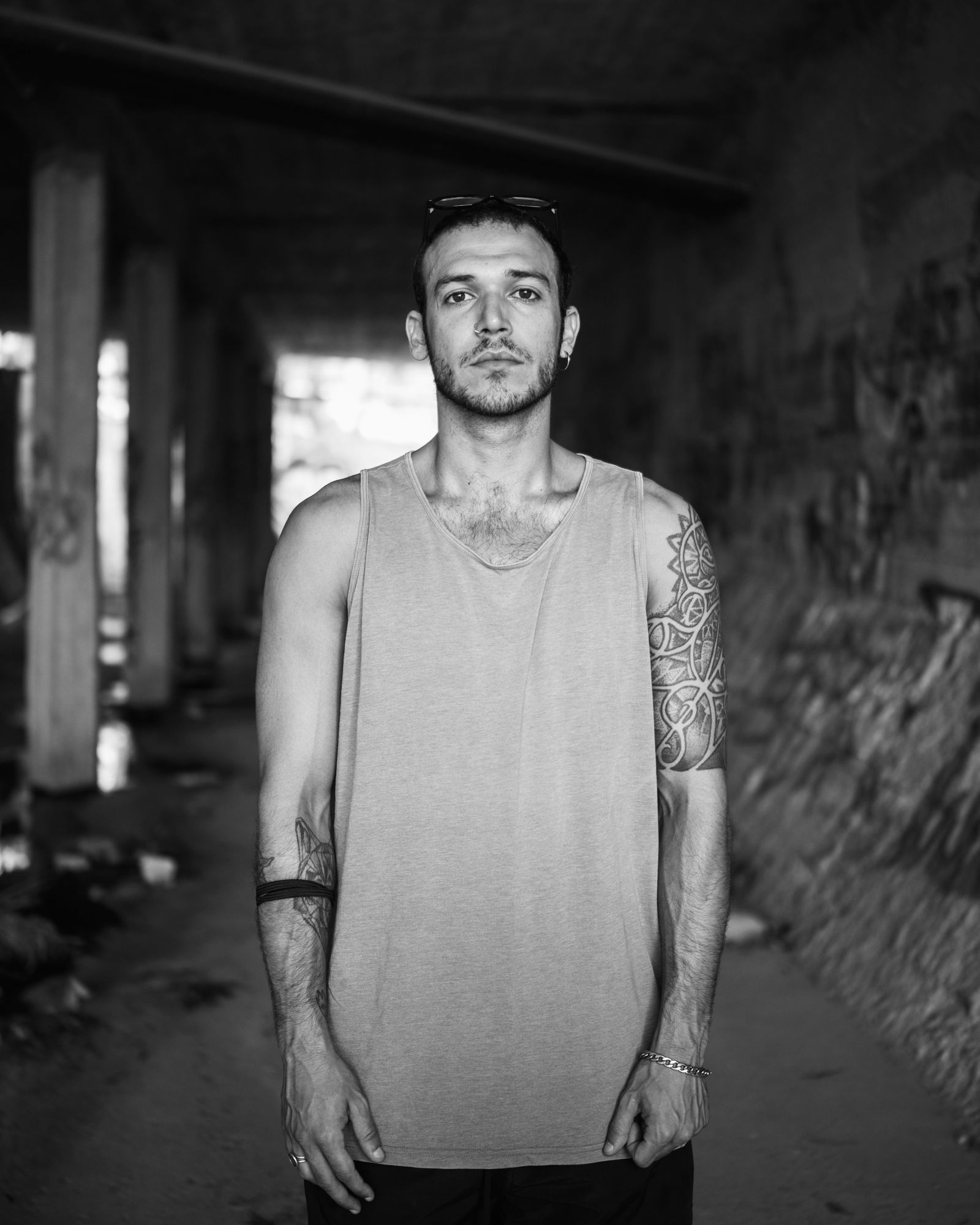 Black and white portrait of Alexandros standing in an abandoned building